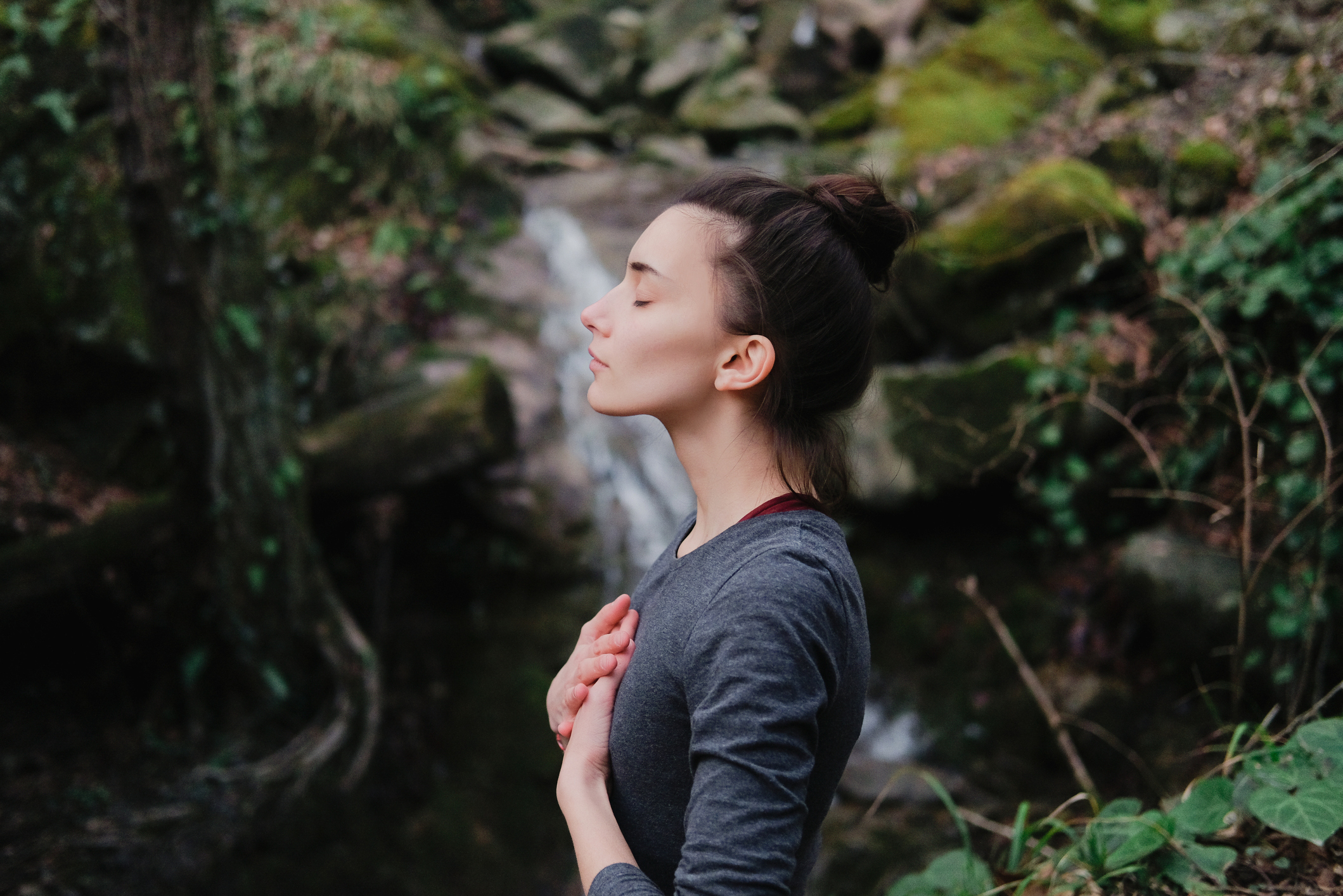 Frau im Wald an Wasserfall